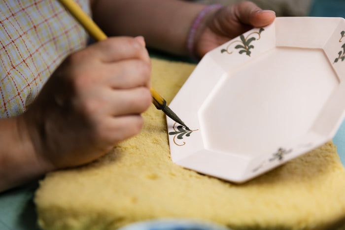 Artisan hand-painting the Floral Leaves pattern on an octagonal Arita ware plate at Kouyou Kiln