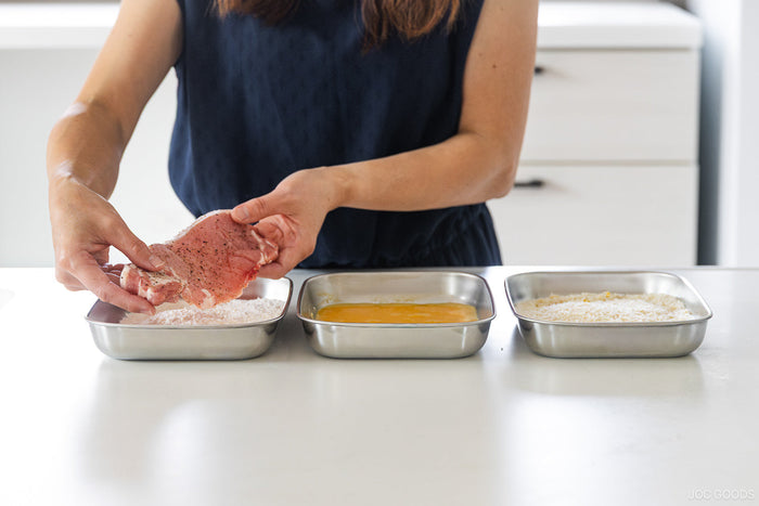 a person prepping food with stainless steel prep trays
