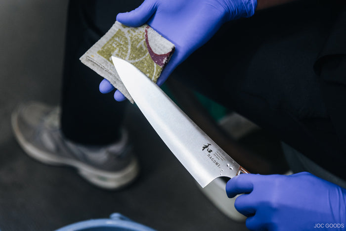 a person cleaning a knife on a cloth
