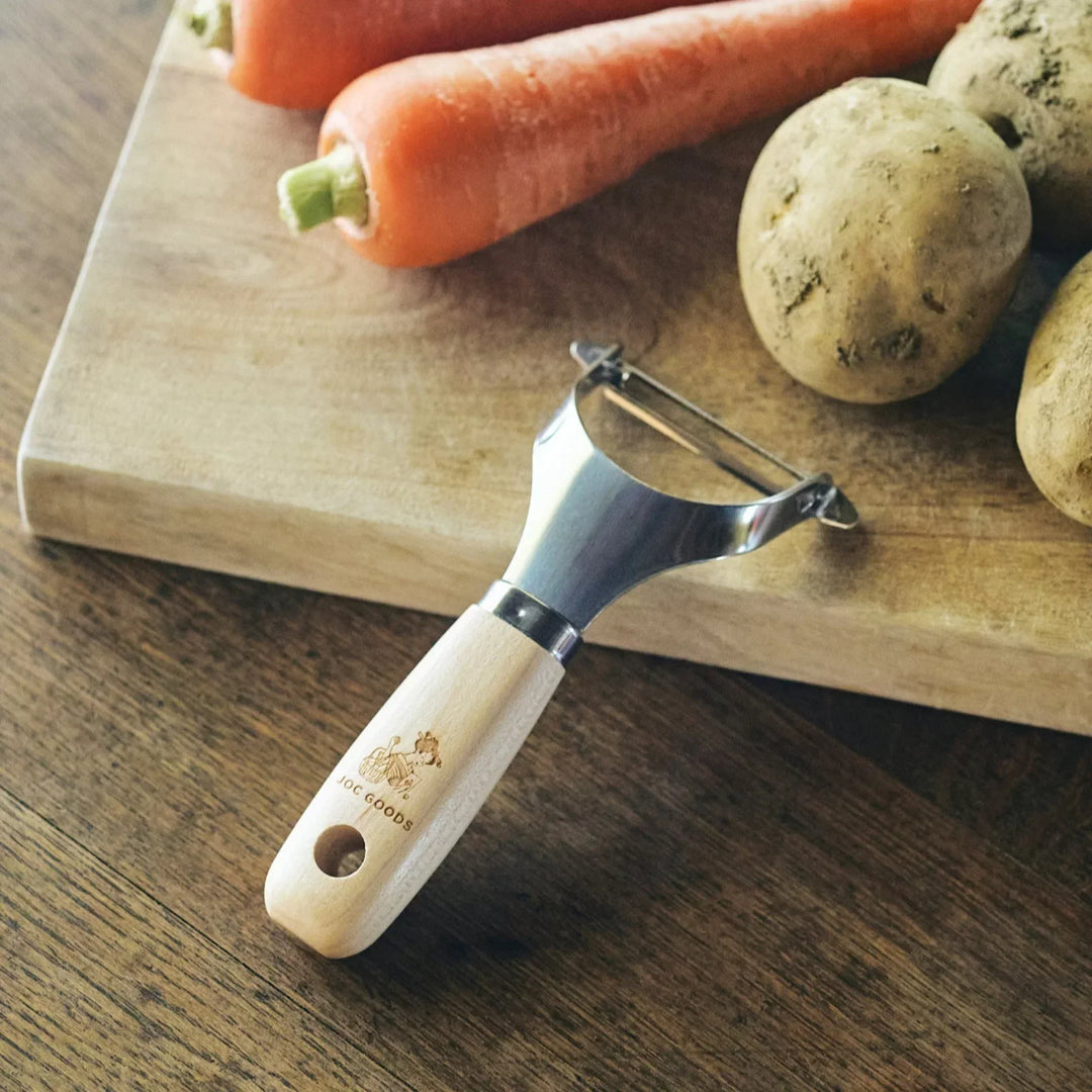 Japanese wood handle peeler with sharp stainless steel blade designed for smooth effortless vegetable peeling.