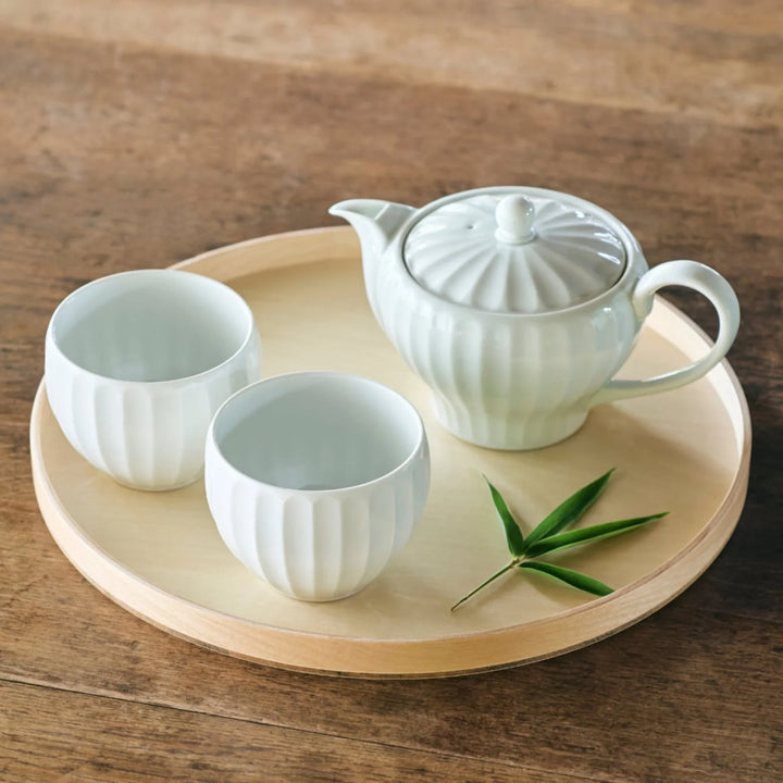 Handcrafted Japanese Petal White Tea Set with teapot and cups on wooden tray with green leaf accent.