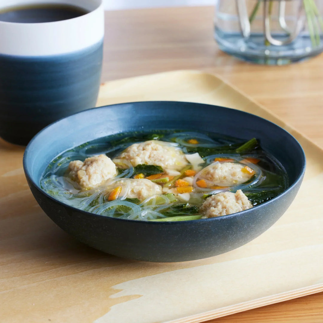 Cozy Japandi Cereal Bowl filled with clear soup, vegetables, noodles, and chicken meatballs, paired with matching cup.
