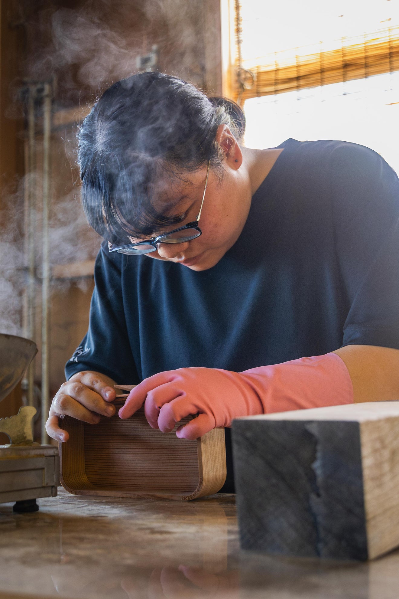Japanese artisan shaping a wooden magewappa style bento box by hand in a traditional woodworking workshop