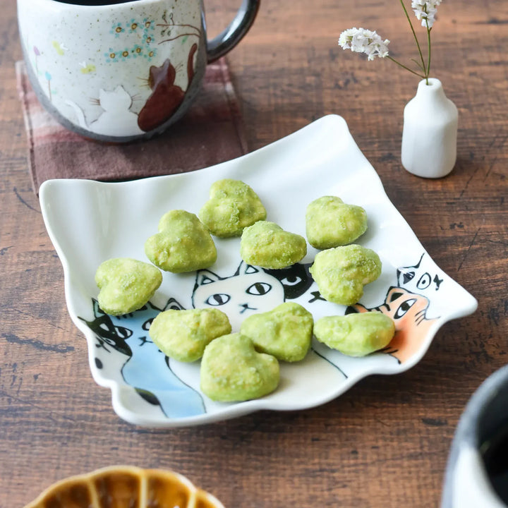 Wavy white dessert plate featuring colorful cats in black, orange, and blue, adding a playful charm to your table.