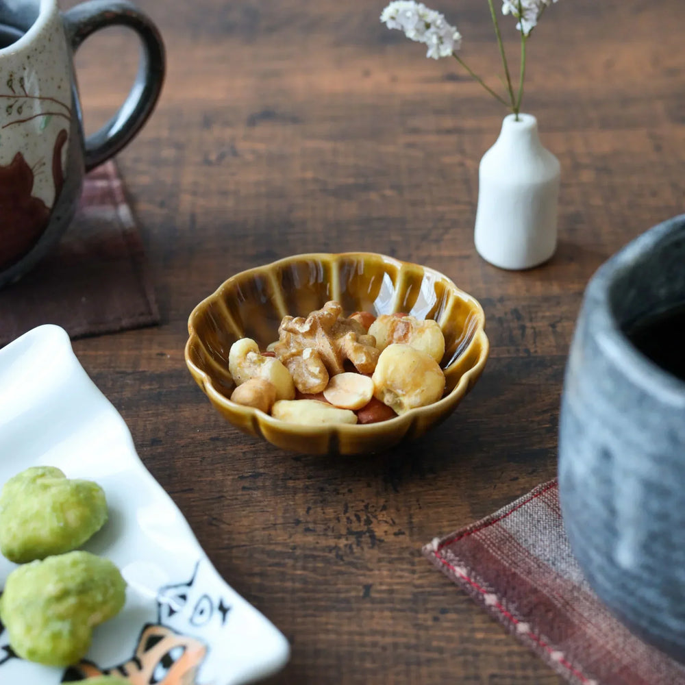 Scalloped flower-petal condiment bowl in warm amber glaze, ideal for serving nuts or sauces with traditional Japanese charm.