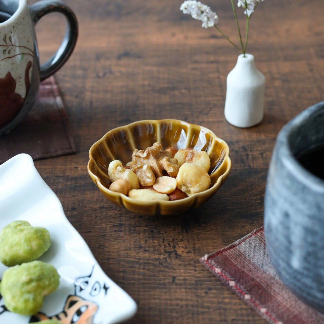 Scalloped flower-petal condiment bowl in warm amber glaze, ideal for serving nuts or sauces with traditional Japanese charm.