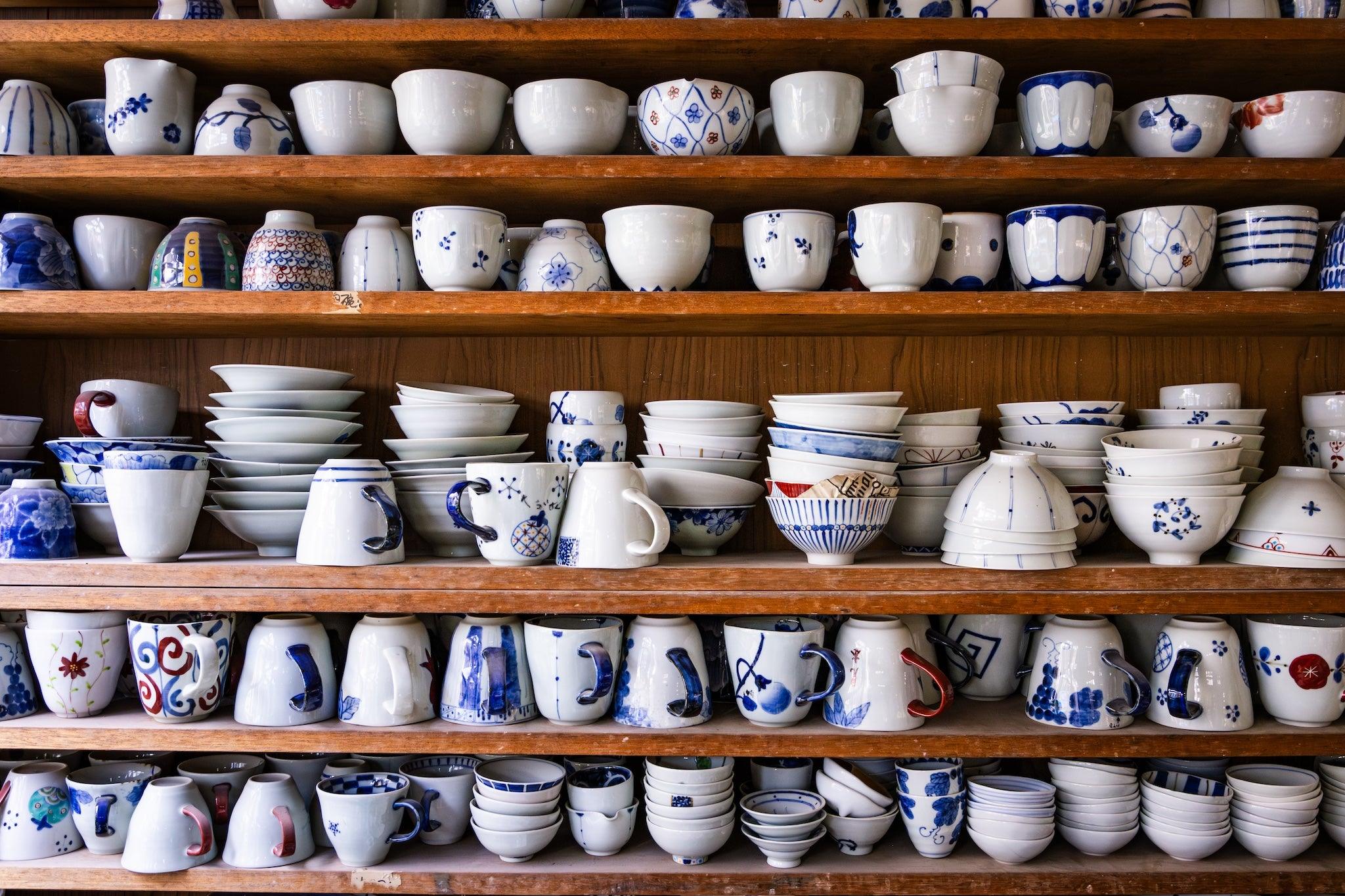 A display of traditional Japanese tableware, showcasing a variety of shapes and intricate blue and white patterns.