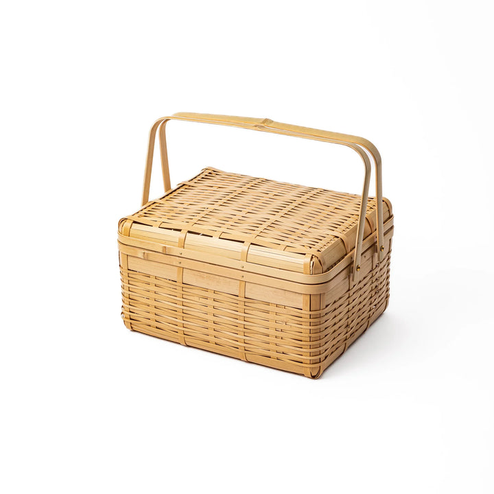 Large Japanese bamboo picnic basket with a sturdy arched handle and a fitted lid for outdoor dining and storage