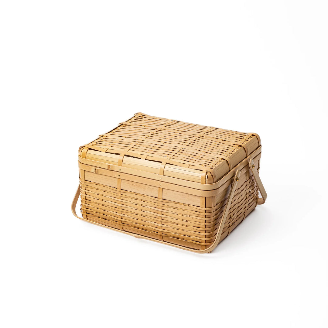 Large Japanese bamboo picnic basket with a sturdy arched handle and a fitted lid for outdoor dining and storage