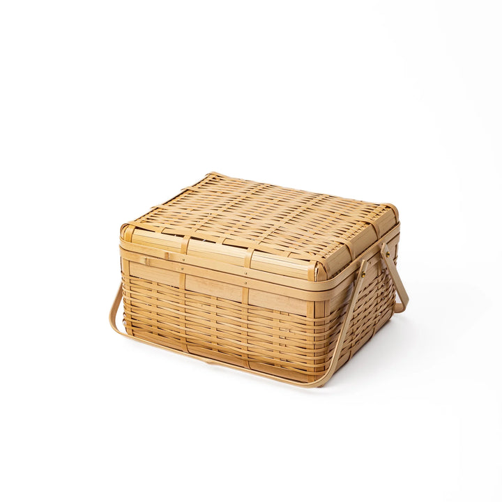 Large Japanese bamboo picnic basket with a sturdy arched handle and a fitted lid for outdoor dining and storage