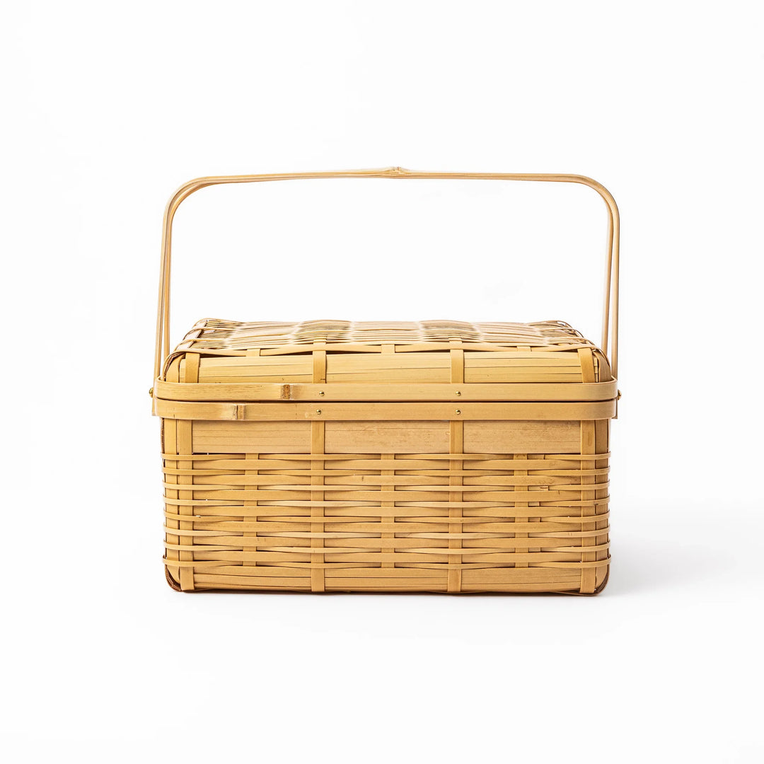 Large Japanese bamboo picnic basket with a sturdy arched handle and a fitted lid for outdoor dining and storage