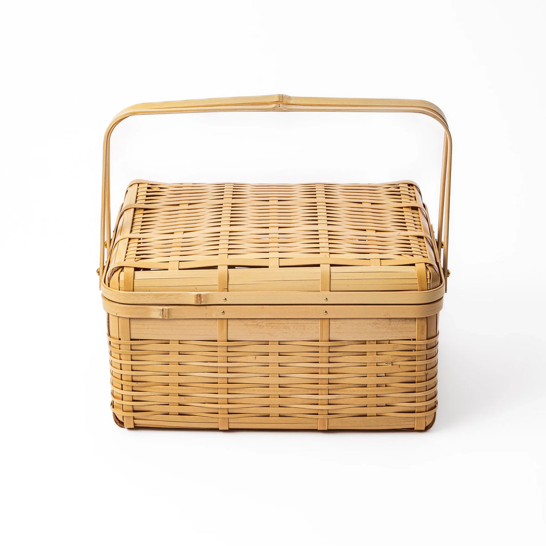 Large Japanese bamboo picnic basket with a sturdy arched handle and a fitted lid for outdoor dining and storage