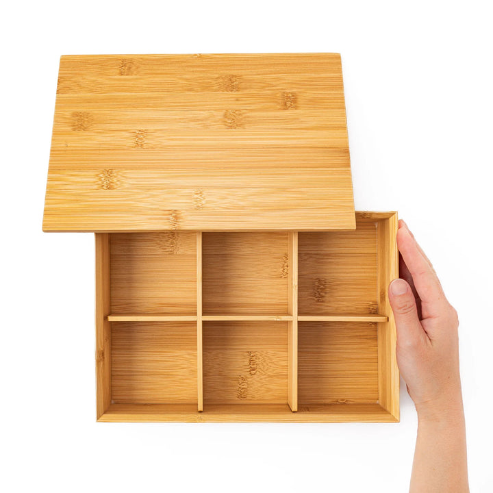 Top down view of an open bamboo bento box with a hand revealing six equal inner compartments for perfect food portioning