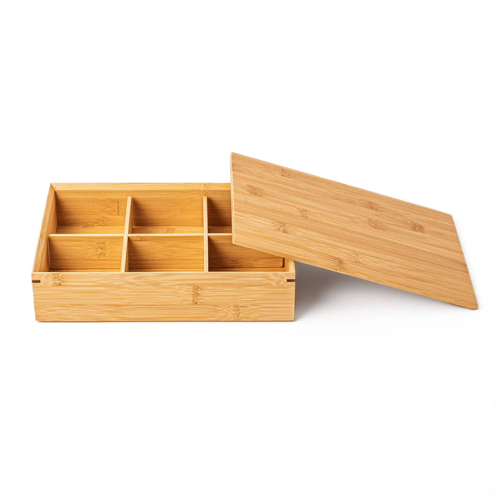 An open six compartment bamboo bento box viewed from the side with its flat lid leaning on the edge showing a sleek profile