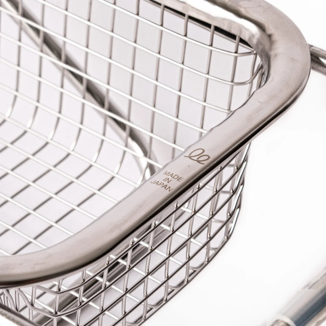 Stainless steel rectangular strainer basket with handles for draining noodles or frying in Japanese cooking.