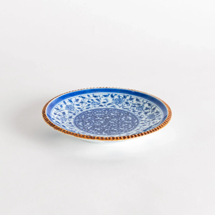 Ceramic plate with blue floral circular motif framed by copper textured rim for elegant Japanese dining.