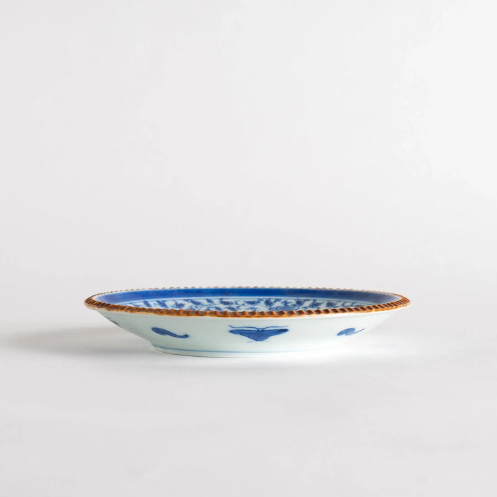 Ceramic plate with blue floral circular motif framed by copper textured rim for elegant Japanese dining.