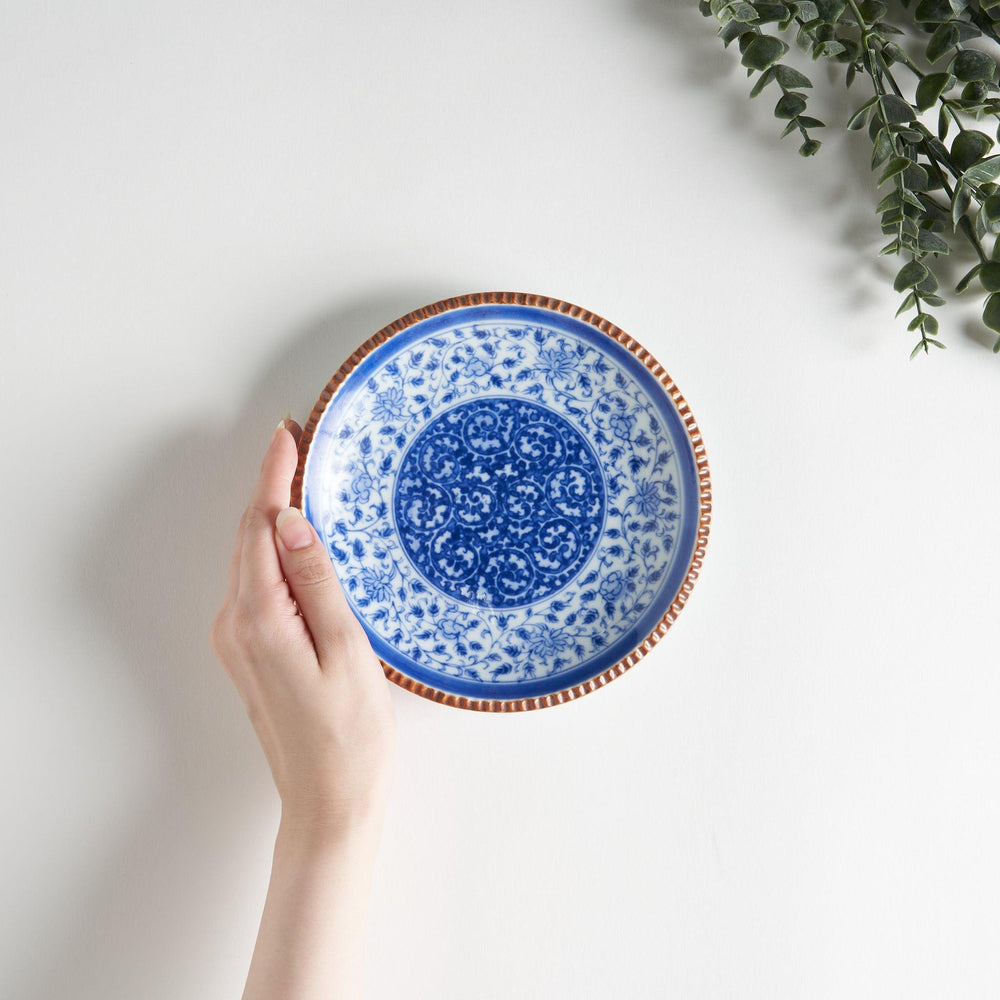 Ceramic plate with blue floral circular motif framed by copper textured rim for elegant Japanese dining.