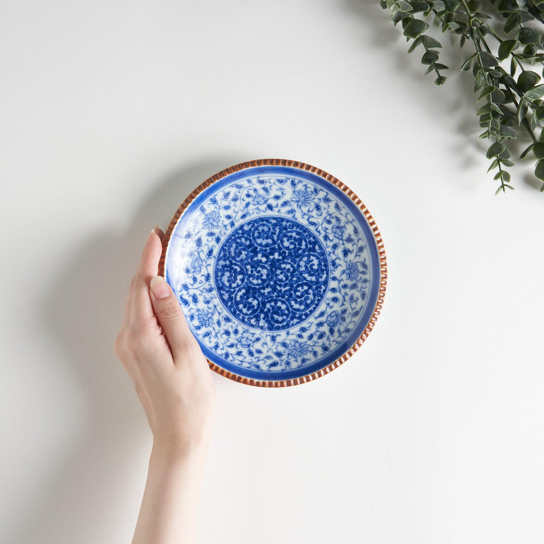 Ceramic plate with blue floral circular motif framed by copper textured rim for elegant Japanese dining.