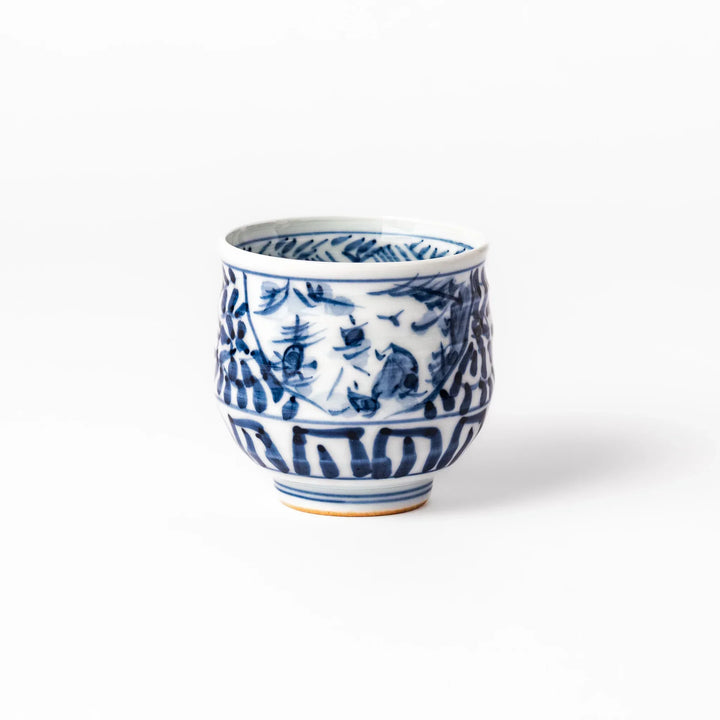 Porcelain sake cup featuring intricate blue landscape and arabesque patterns with a traditional hand-painted indigo design.