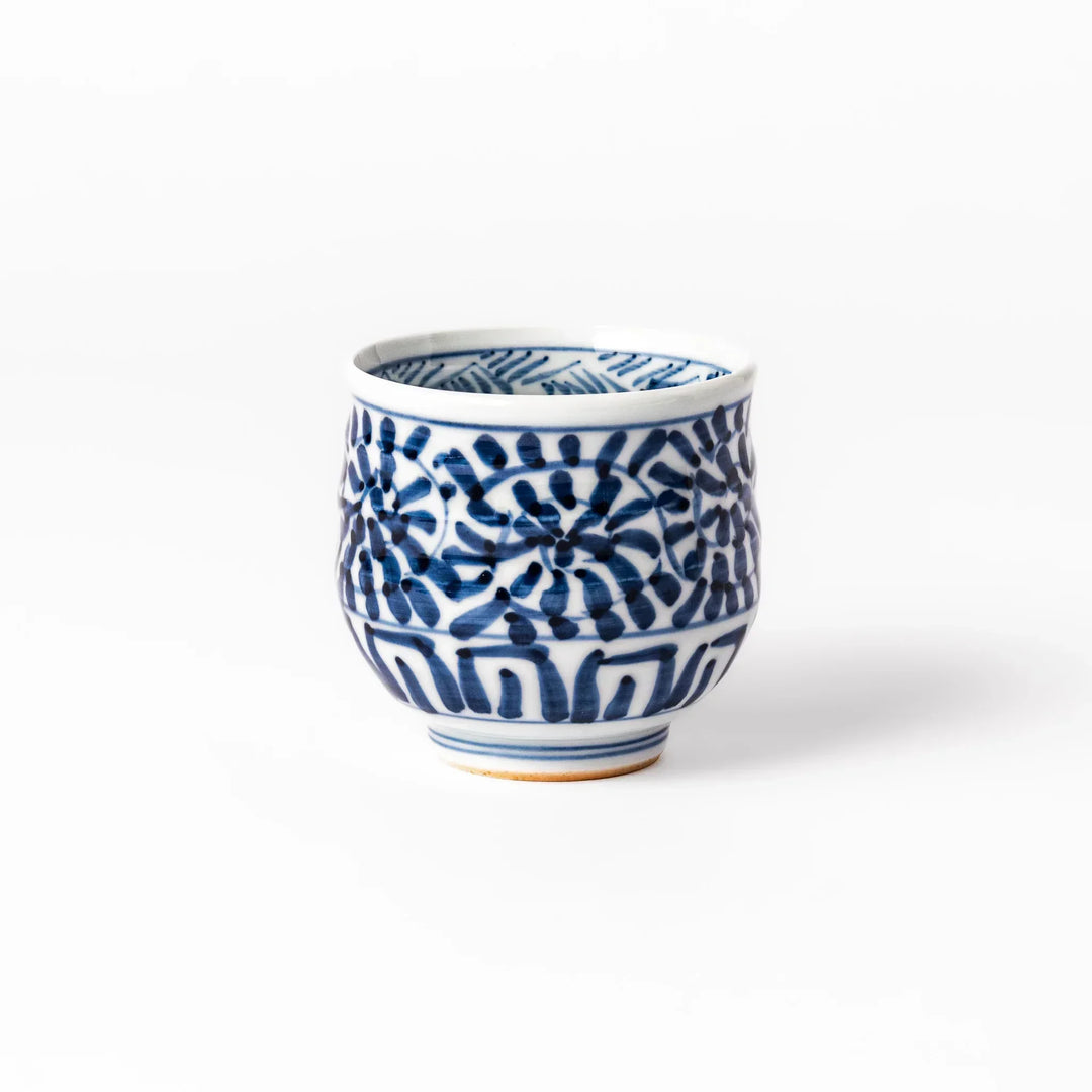 Porcelain sake cup featuring intricate blue landscape and arabesque patterns with a traditional hand-painted indigo design.