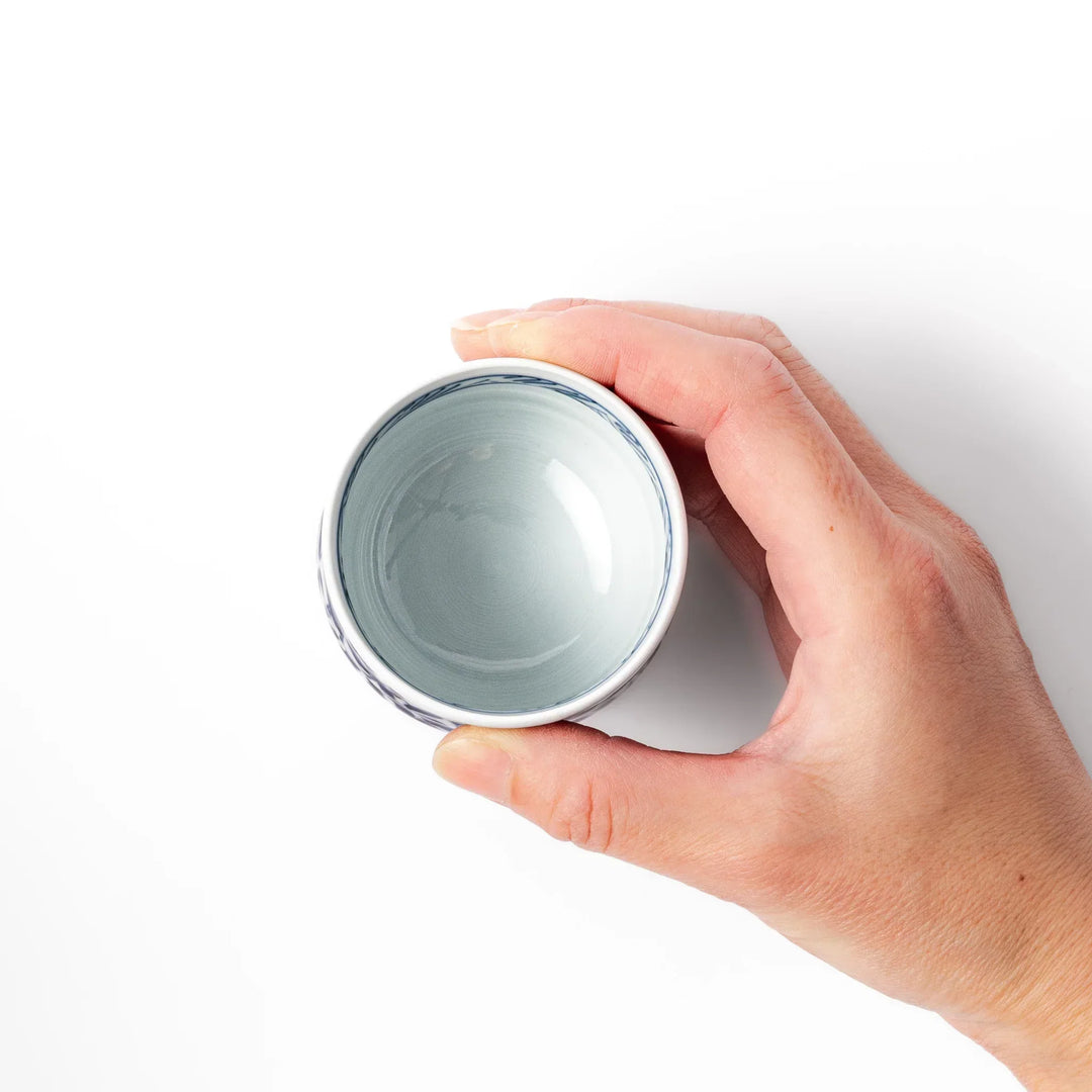 Porcelain sake cup featuring intricate blue landscape and arabesque patterns with a traditional hand-painted indigo design.