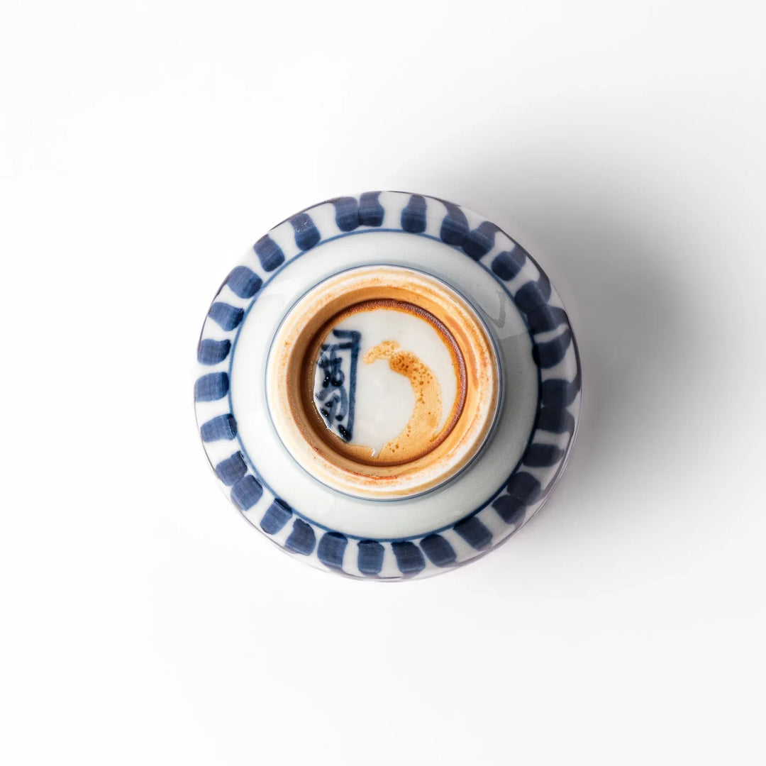 Porcelain sake cup featuring intricate blue landscape and arabesque patterns with a traditional hand-painted indigo design.