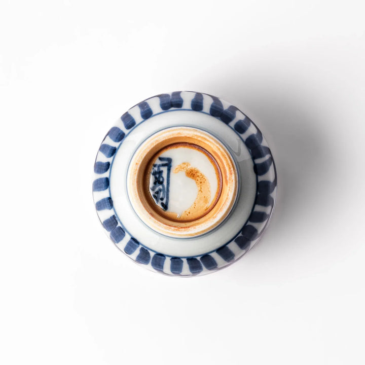 Porcelain sake cup featuring intricate blue landscape and arabesque patterns with a traditional hand-painted indigo design.