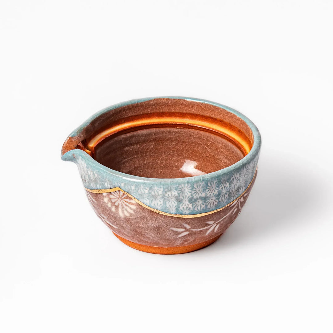 Turquoise crackle-glazed teapot with floral patterns and gold-accented spout, blending elegance and craftsmanship.