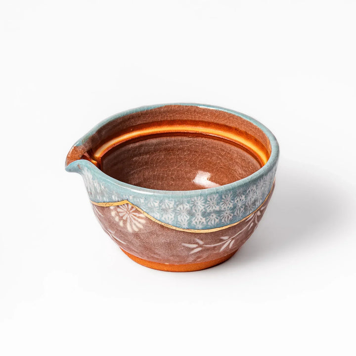 Turquoise crackle-glazed teapot with floral patterns and gold-accented spout, blending elegance and craftsmanship.