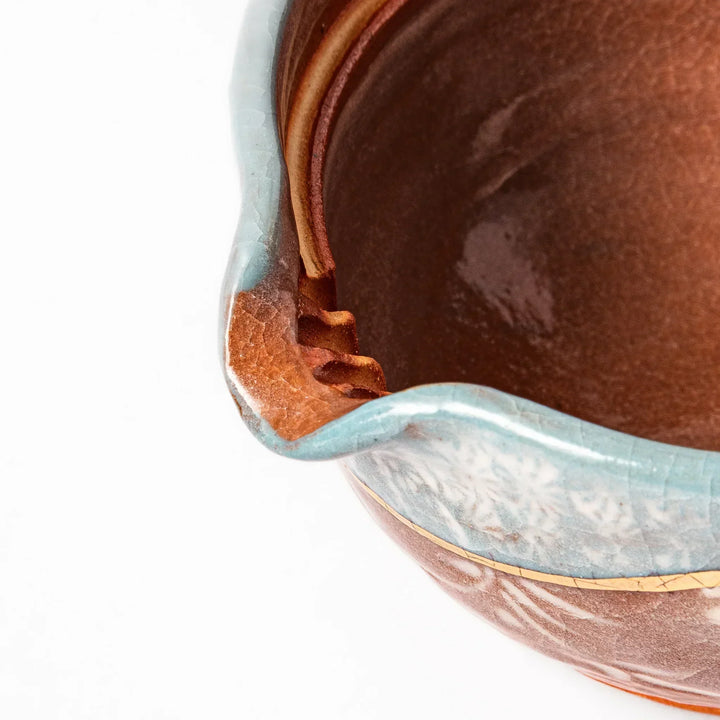 Turquoise crackle-glazed teapot with floral patterns and gold-accented spout, blending elegance and craftsmanship.