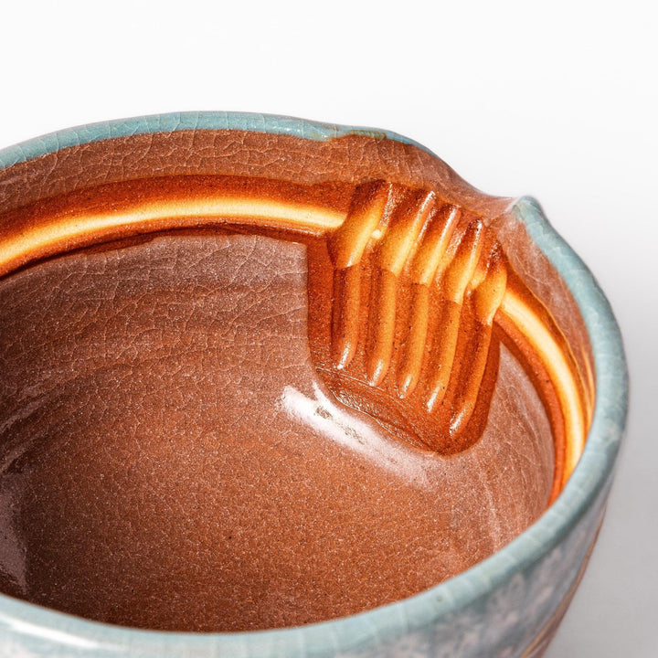 Turquoise crackle-glazed teapot with floral patterns and gold-accented spout, blending elegance and craftsmanship.