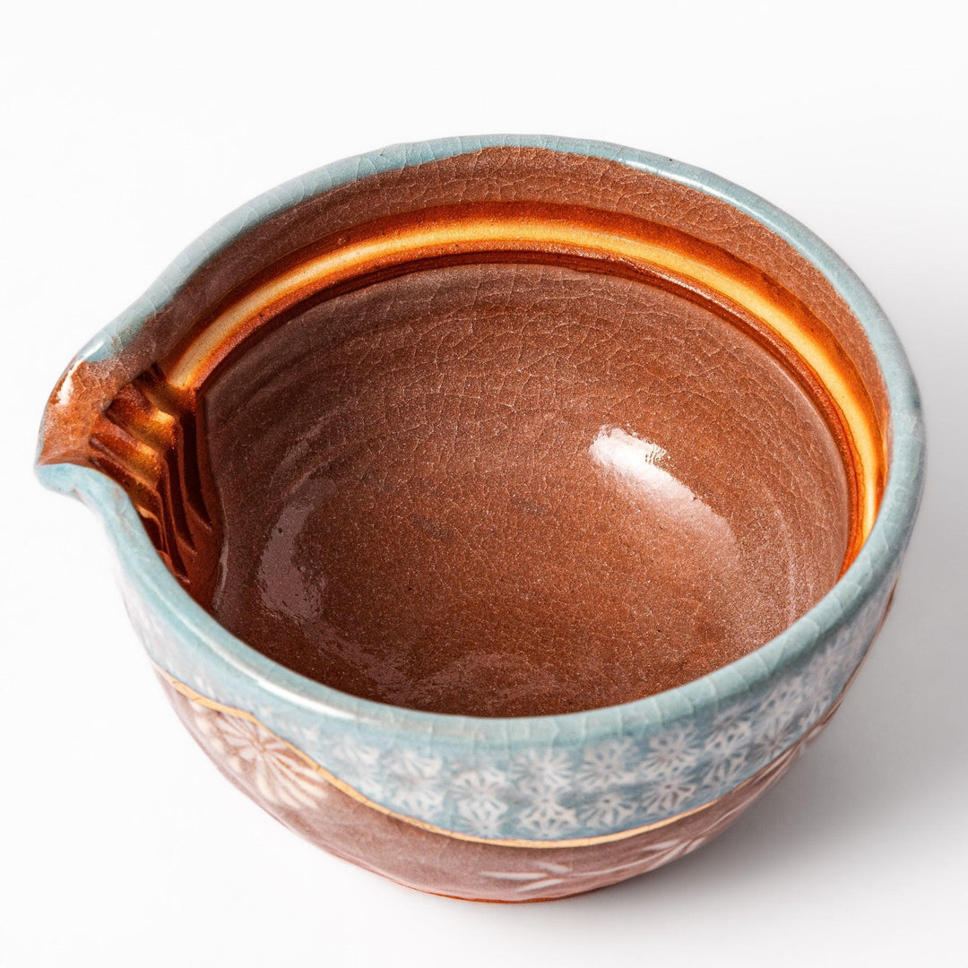 Turquoise crackle-glazed teapot with floral patterns and gold-accented spout, blending elegance and craftsmanship.