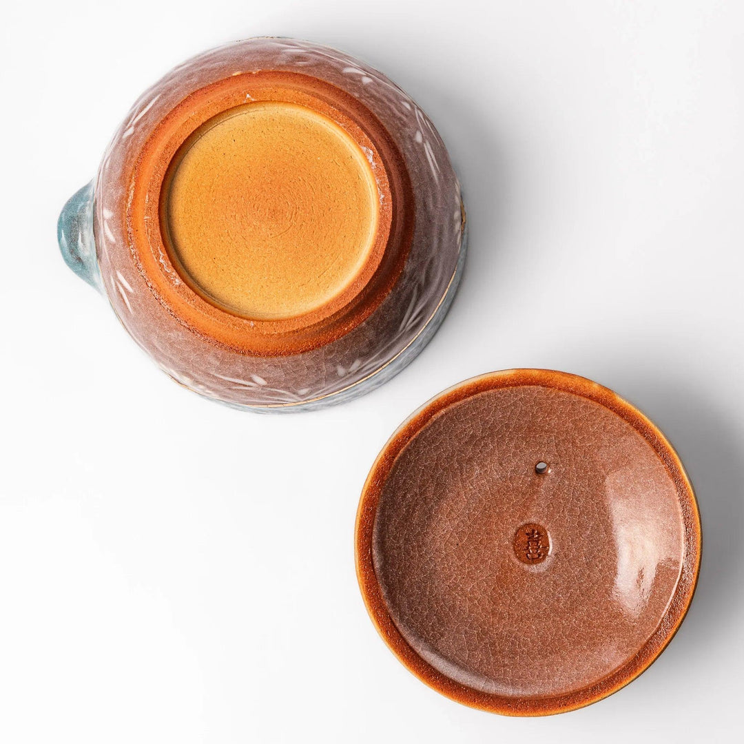 Turquoise crackle-glazed teapot with floral patterns and gold-accented spout, blending elegance and craftsmanship.