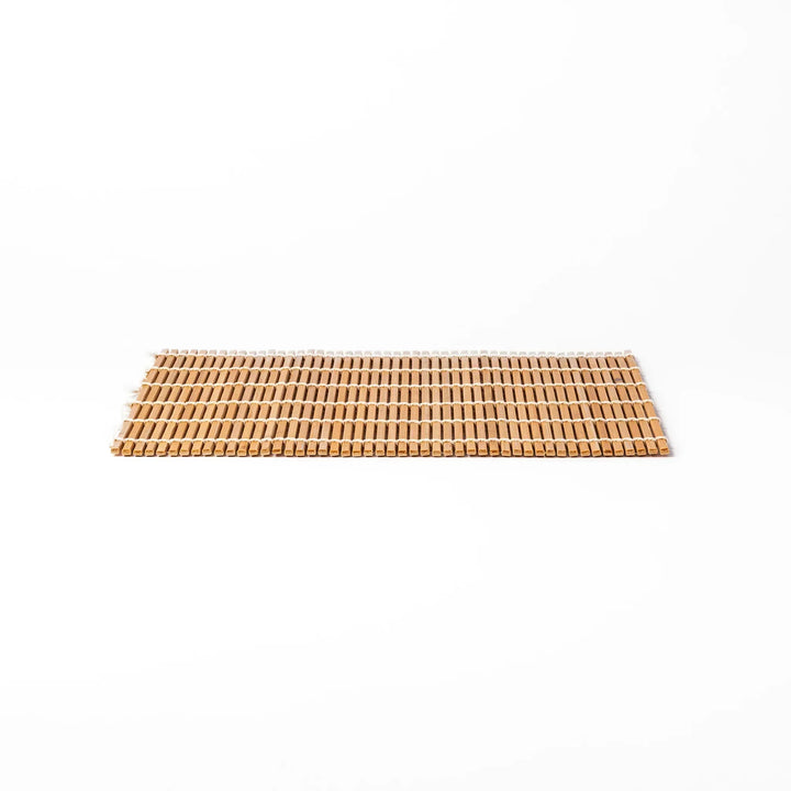 Traditional bamboo sushi rolling mat with uniform slats and white cotton string for home sushi making.