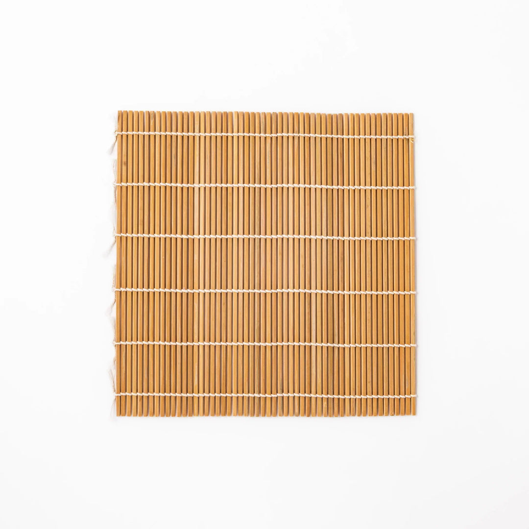 Bamboo sushi rolling mat with smooth even slats and white cotton string for shaping homemade sushi rolls.