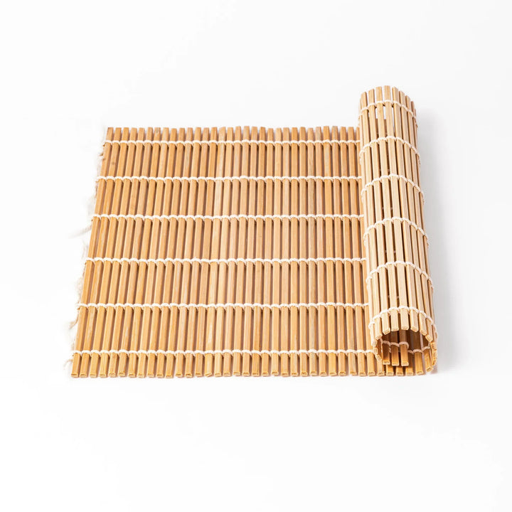 Bamboo sushi rolling mat with smooth even slats and white cotton string for shaping homemade sushi rolls.