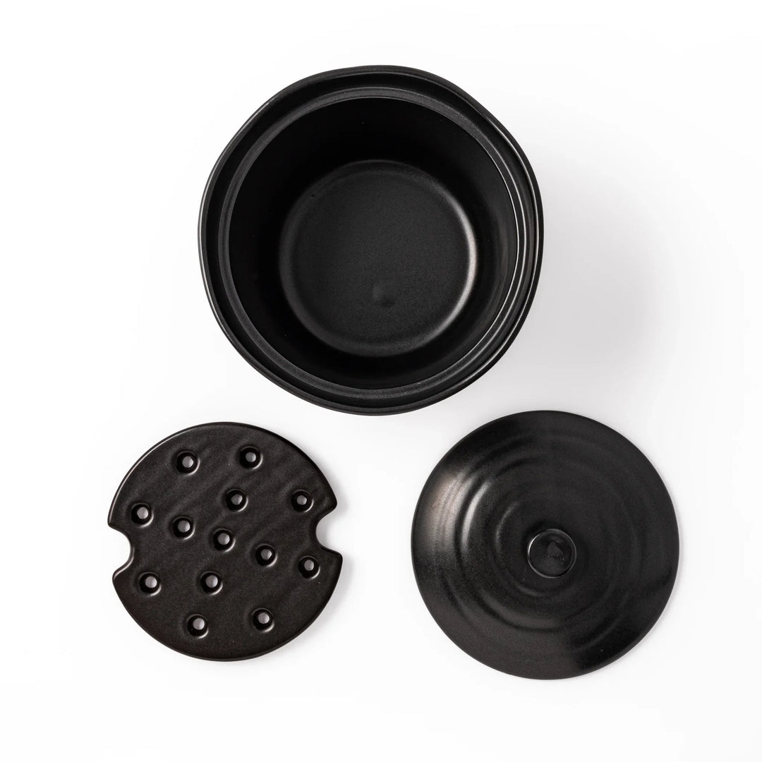 Black ceramic rice storage bowl with floral ridge lid design, compact size for storing cooked rice and keeping it warm.