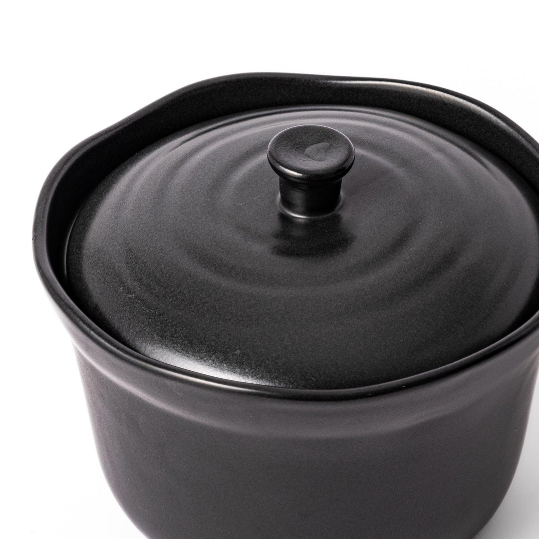 Black ceramic rice storage bowl with floral ridge lid design, compact size for storing cooked rice and keeping it warm.