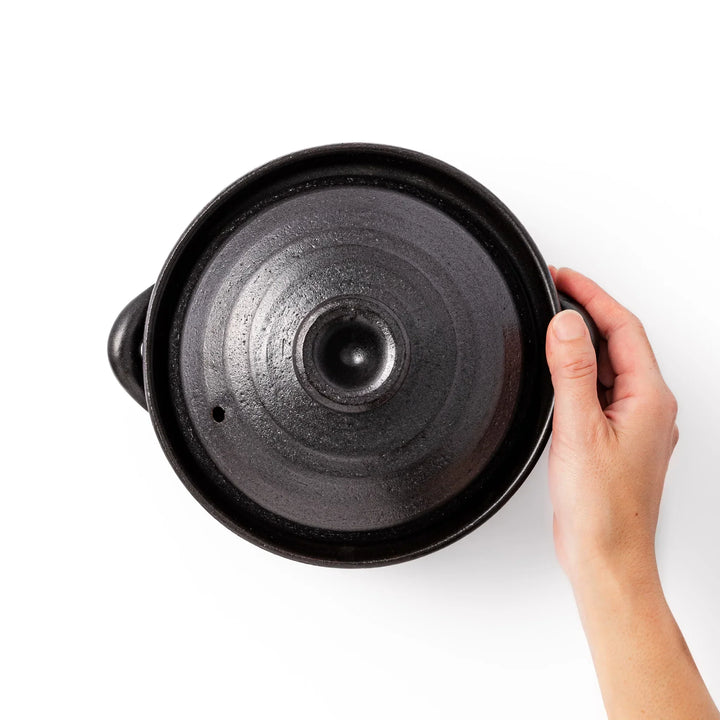 Black clay donabe with induction-compatible design, featuring double lid and side handles, ideal for cooking 2 cups of rice.