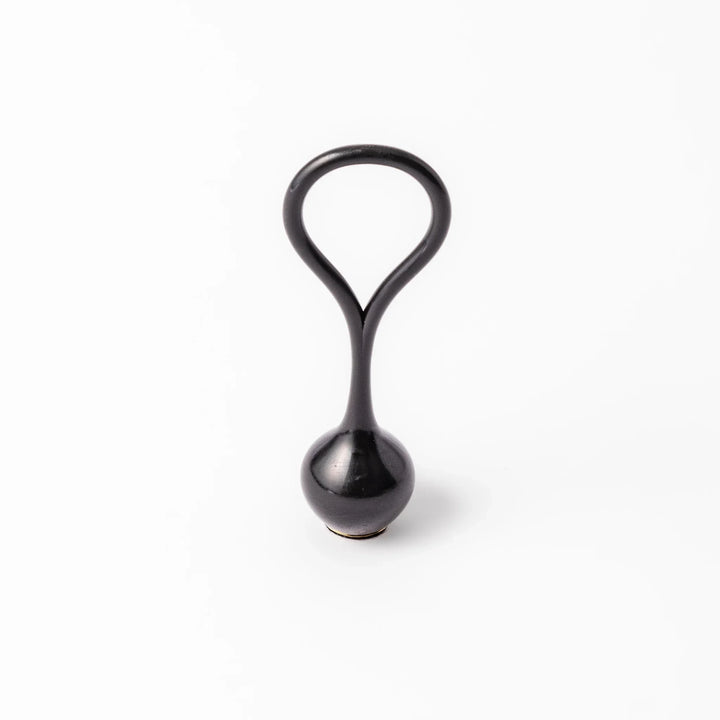 Black meditation bowl striker with looped handle and felt tip for gentle resonant sounds in prayer rituals.