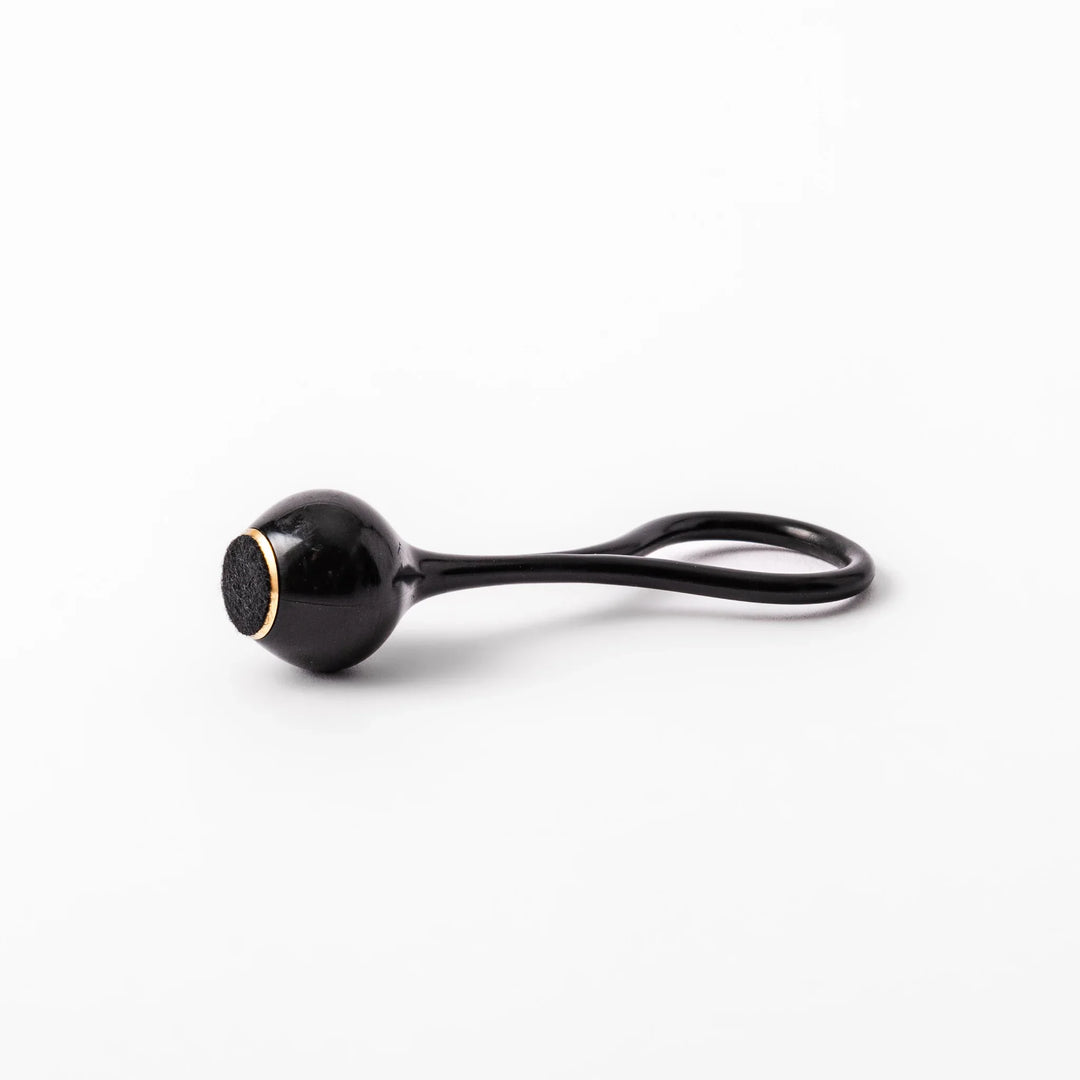 Black meditation bowl striker with looped handle and felt tip for gentle resonant sounds in prayer rituals.