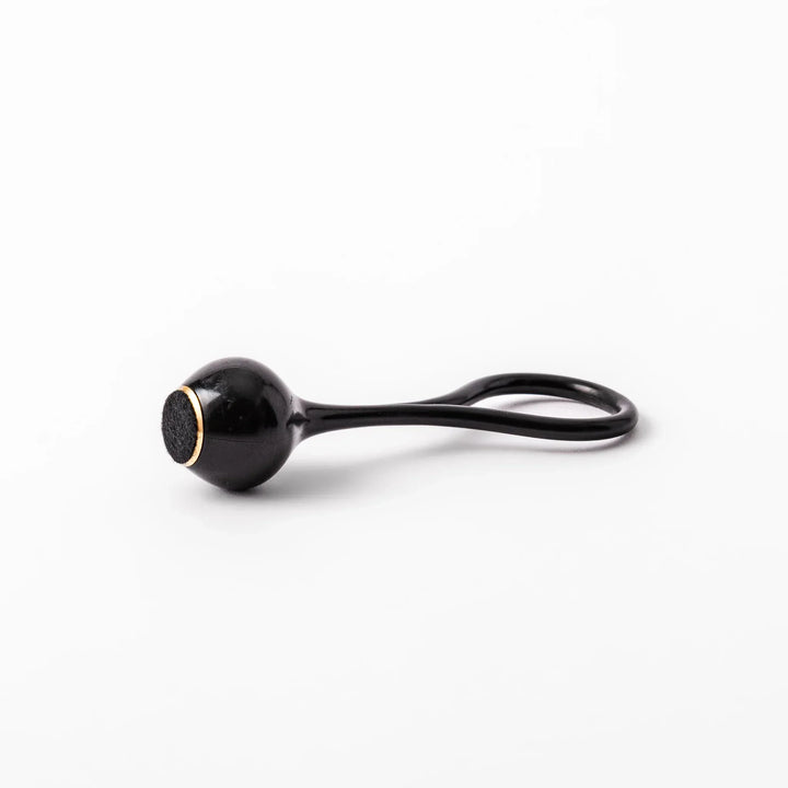 Black meditation bowl striker with looped handle and felt tip for gentle resonant sounds in prayer rituals.