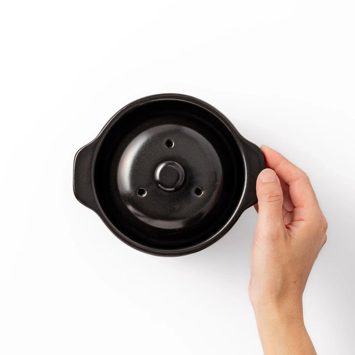 Black ceramic microwave rice cooker with double lid and handles for convenient cooking and table serving.