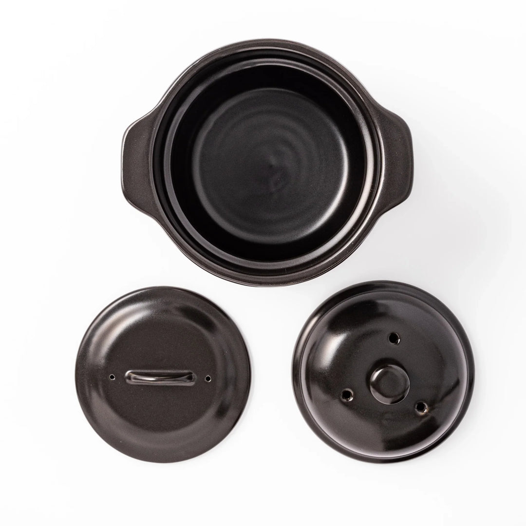 Black ceramic microwave rice cooker with double lid and handles for convenient cooking and table serving.