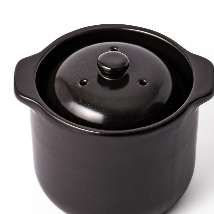 Black ceramic microwave rice cooker with double lid and handles for convenient cooking and table serving.