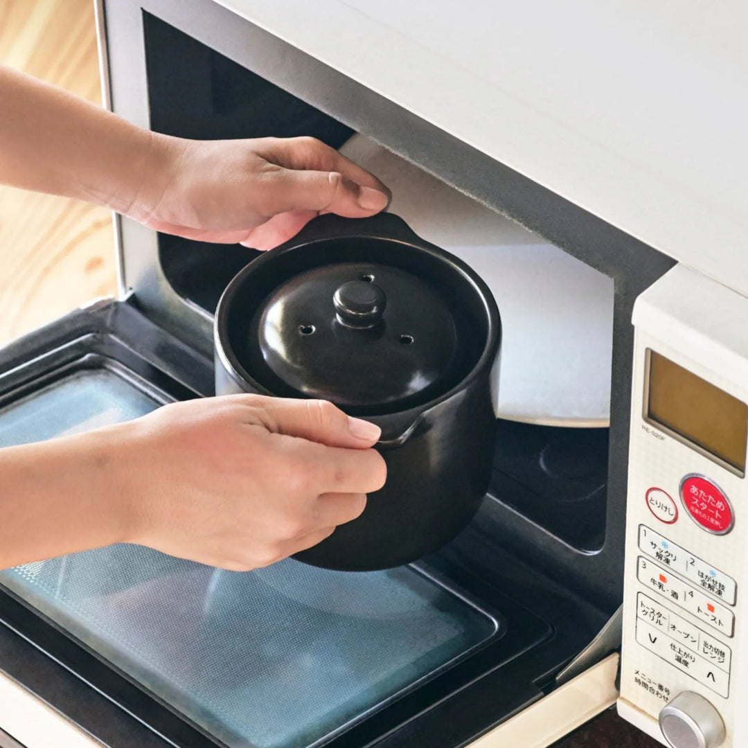 Black ceramic microwave rice cooker with double lid and handles for convenient cooking and table serving.