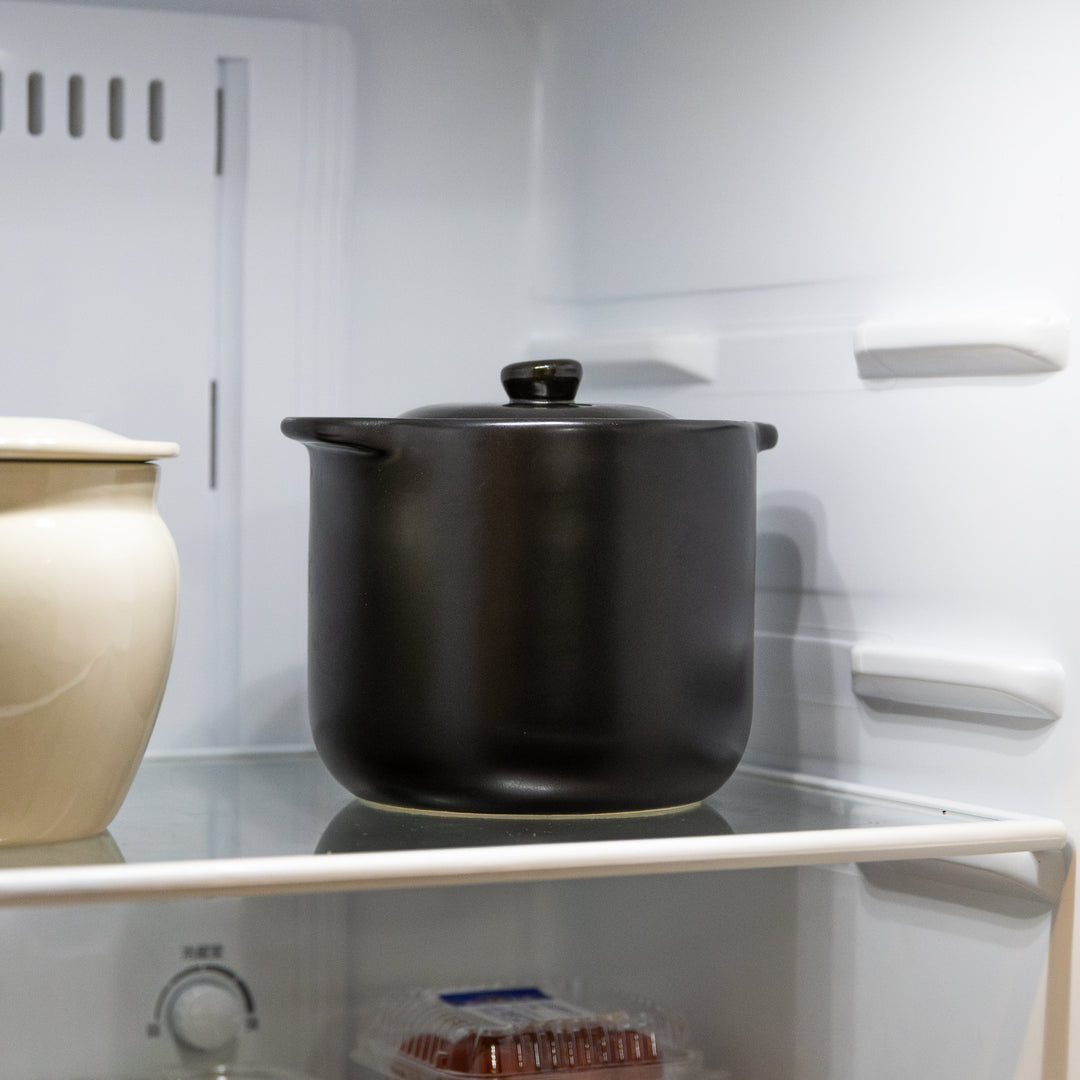 Black microwave rice cooker with double lid stored in refrigerator for rice keeping