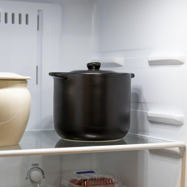 Black microwave rice cooker with double lid stored in refrigerator for rice keeping