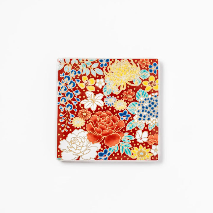 Square Japanese ceramic coaster with vivid red base featuring peony, chrysanthemum, and floral motifs in multicolor design.